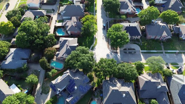 Suburban solar roof panels on corner house of upscale residential area in West Plano, Texas, two story suburban home lush green trees, clean energy, suburbs Dallas Fort Worth metroplex, flyover