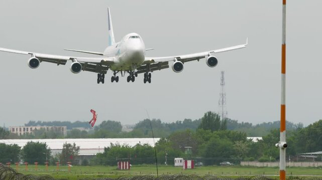 Widebody cargo airliner is landing, touching and braking withe smoke. Spoilers up. Airplane jumbo jet is arriving, cinematic shot