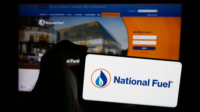 Stuttgart, Germany - 08-19-2024: Person holding mobile phone with logo of American oil and gas business National Fuel Gas Company in front of web page. Focus on phone display.