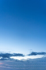 Beautiful blue sky and sea with white clouds and sunlight, showcasing a sunny day at the ocean horizon