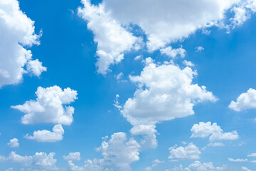Bright blue sky with fluffy white clouds on a sunny day