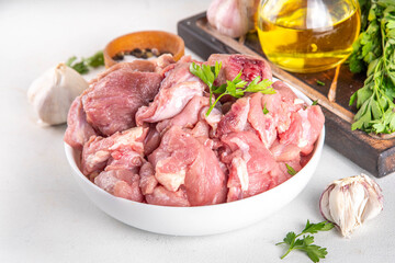 Veal, beef red meat raw chopped goulash, with herbs, condiment, olive oil and spices, cooking dinner background copy space