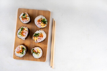 Gimbap or kimbap, korean rolls, traditional dish. Homemade kimbap roll with ham, vegetables and lettuce