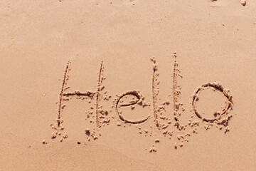 the inscription hello  on the seashore with palm trees
