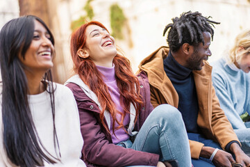 Diverse friends laughing outdoors, multicultural group enjoying time together, inclusive friendship portrait