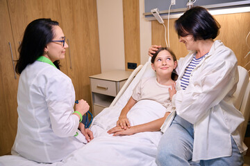 Fototapeta premium Woman doctor communicates with a girl and her mother