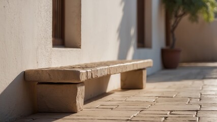 Stone bench with brown tiles near white adobe wall.