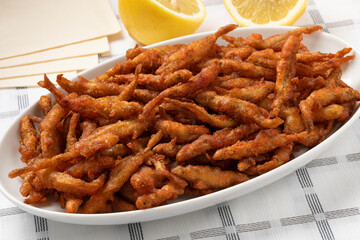 Plate with deep fried smelt fish close up
