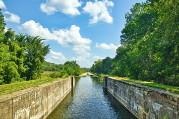 Fototapeta premium Sunny Summer day landscape of a recreational trail beside the remains of a lock on the Hennepin Canal in Northern Illinois