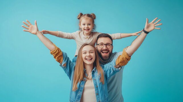 A joyful family with a child playfully posing against a bright blue background, showcasing love and happiness in a lively indoor setting