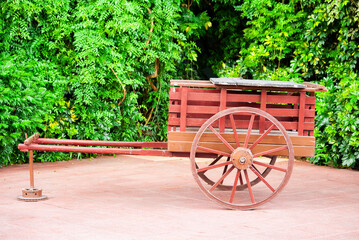 Old cart, horse-drawn means of transportation, historical object displayed in an outdoor garden area in a city in Latin America.