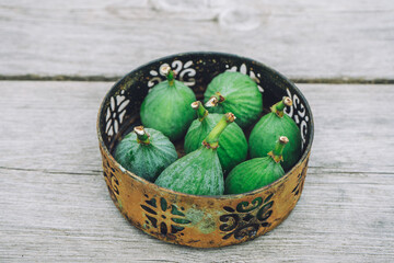 A few figs in a rusty bowl on a wooden table. In Sweden.