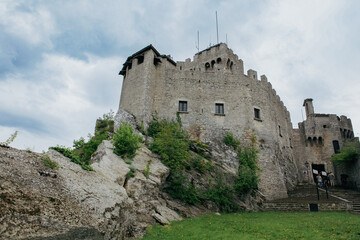 Historic architecture of San Marino with ancient castle and green landscape under cloudy sky