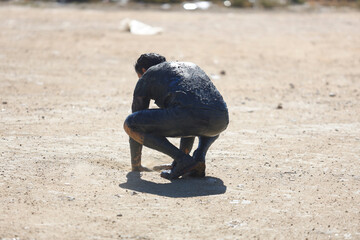 muddy and tired person in an obstacle race