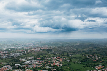 A panoramic view of the rolling hills and dramatic skies over San Marino on an overcast day