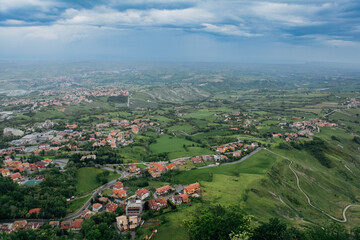 A panoramic view of the lush landscape in San Marino under a cloudy sky