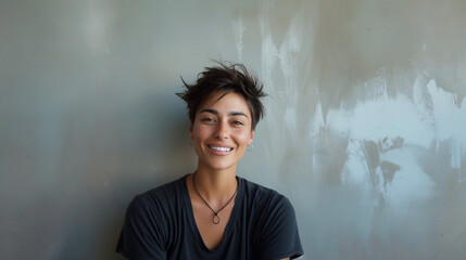 Portrait of attractive non-binary individual against wall.