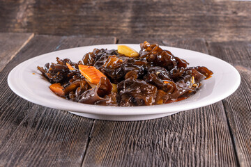 Wood Ear Mushroom Salad on wood table. Chinese food. wooden sticks, soy sauce. China Sichuan Food