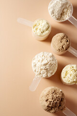 Protein powder in scoops. Different flavours of whey protein powder, copy space.