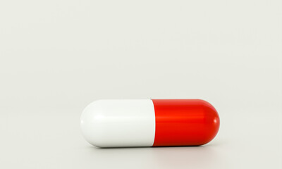 Red and white pill lying on white background