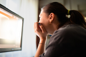 A young woman is sitting at a computer in the office