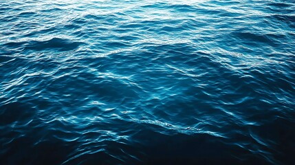 A close-up shot of a deep blue ocean with gentle waves, showing the surface's mesmerizing ripple patterns and shimmering reflections.