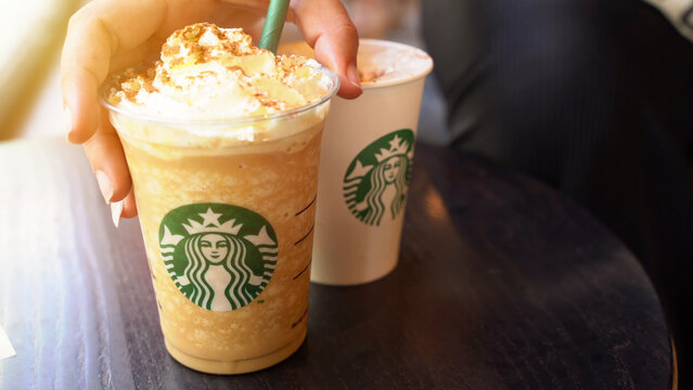 Detail of hand taking a Starbucks pumpking spice latte