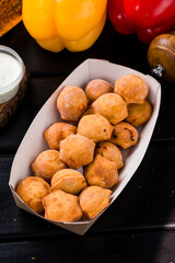 Fried dumplings with meat, herbs and sauce in a paper box.