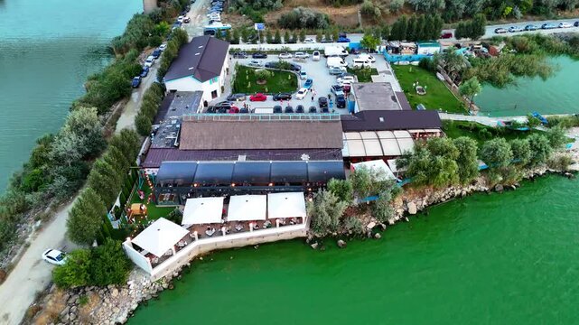 Reverse aerial view of a property by the lake in Navodari at sunset