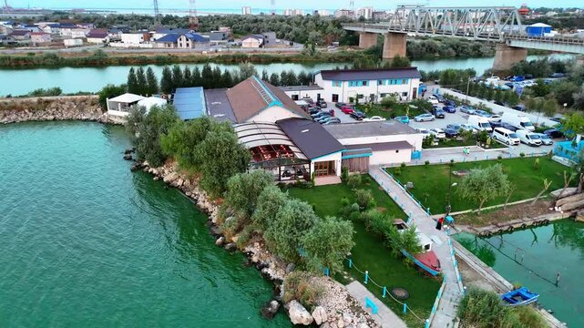 Aerial view rotating around a property by Tasaul Lake where people enjoy eating fish