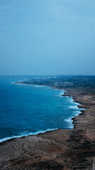Aerial view of landscape with a sprawling shoreline and blue ocean.