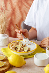 the girl is eating yogurt with granola. healthy breakfast