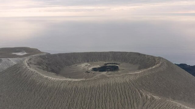 Aerial arc view of crater at top of Barcena cinder cone volcano, San Benedicto
