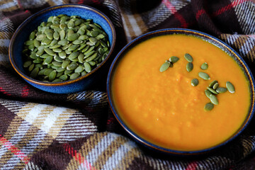 Carrot Ginger Soup With Pumpkin Seeds In Blue Bowl