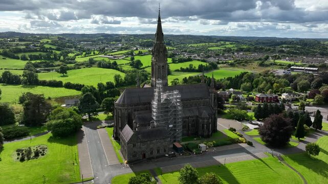St. Macartan's Cathedral, County Monaghan, Ireland, September 2022. Drone orbits clockwise around the restoration scaffolding and ornate Gothic Revival architecture with Monaghan Town in the distance.