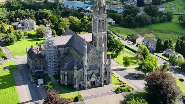 St. Macartan's Cathedral, County Monaghan, Ireland, September 2022. Drone zooms in and orbits counter clockwise showcasing the Roman Catholic stone church surrounded by the Monaghan town cityscape.