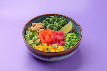 Top view of a colorful salmon poke bowl with fresh vegetables and rice, presented
