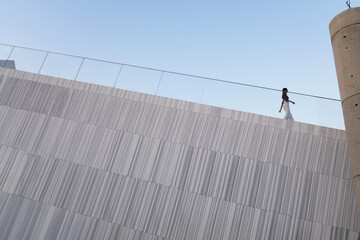 Obraz premium A woman is walking up a set of stairs while looking at her cell phone