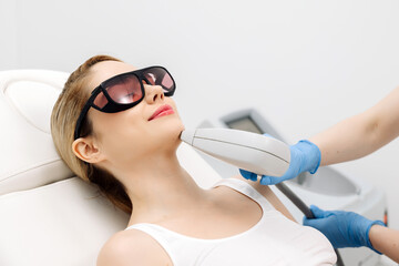Laser hair removal procedure in an aesthetic clinic, focusing on facial hair removal from a female...