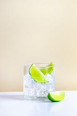 Strong alcoholic cocktail drink with craft rum, sugar syrup and lime. Beige background