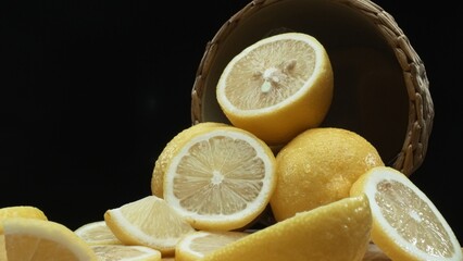 Close up of lemon slices are meticulously arranged against a rustic basket backdrop on a deep black...