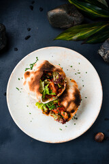 Snack pita with fried chicken in sweet and sour sauce, arugula, lettuce and greens.