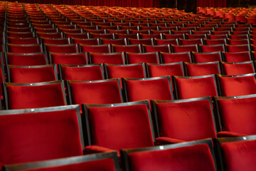 Naklejka premium Several red theater seats, with symmetrical framing between the chairs.