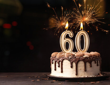 Birthday cake with 60 years birthday candle with sparks on dark background with copy space	