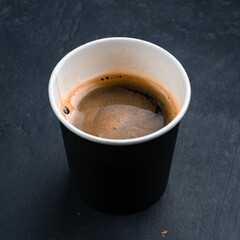 A cup of hot espresso coffee, black coffee in paper cup.