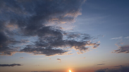 Summer evening sky in the picturesque clouds, lit by the rays of the setting sun.
