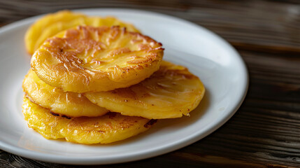 White plate is adorned with a stack of four golden, crispy potato pancakes, exuding an irresistible aroma