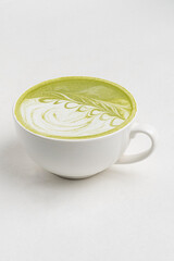 matcha latte in white cup on the white