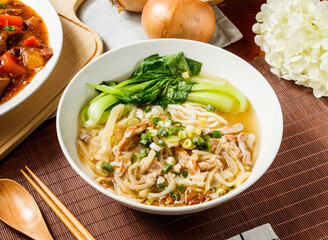 Mustard Pork Noodles soup with green onion in bowl isolated on napkin side view on table taiwan food