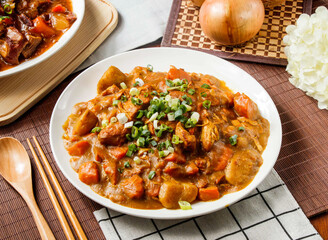 Savory Chicken Curry with Vegetables include carrot, potato and green onion in plate isolated on wooden table side view of taiwan food